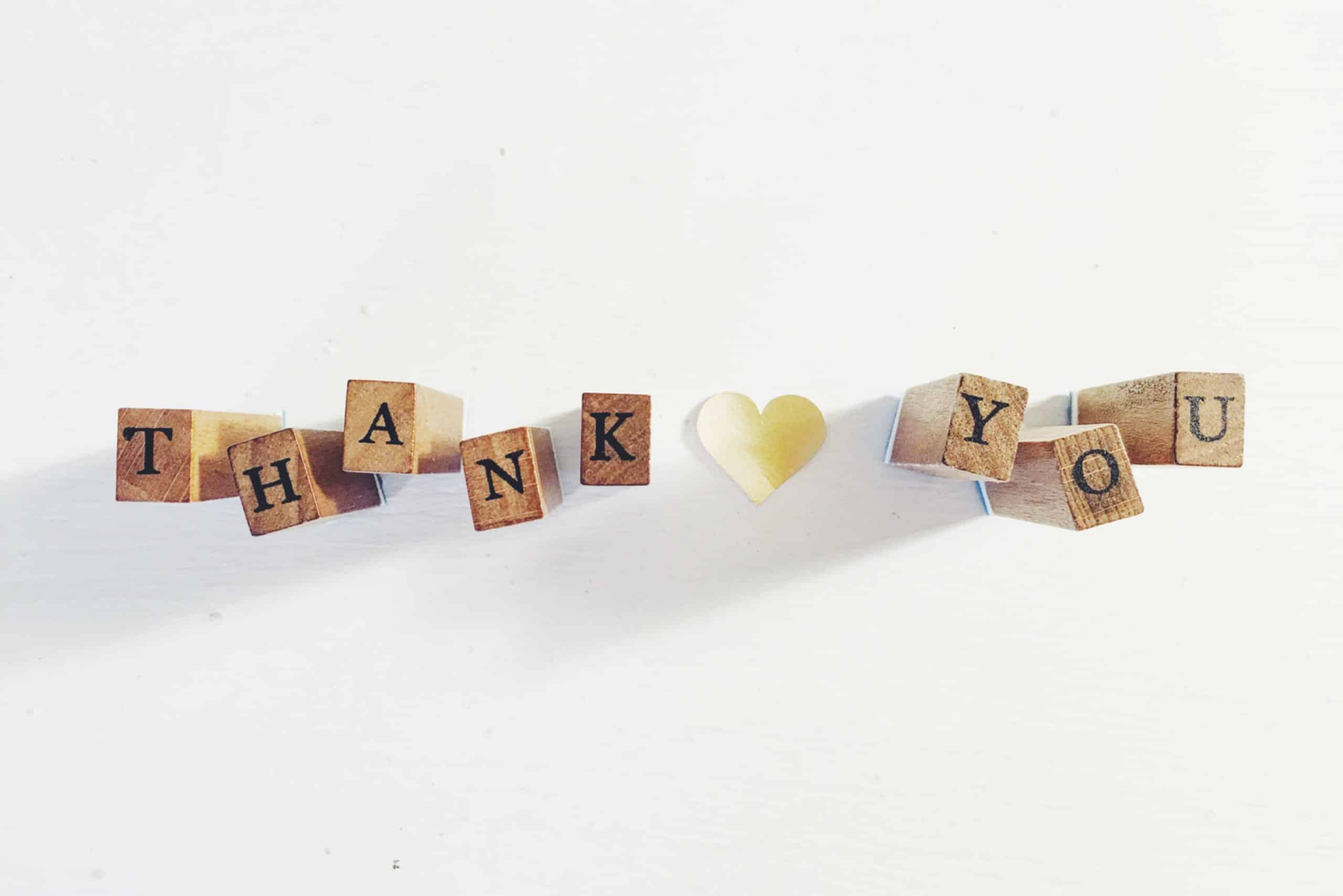 "Thank you" spelled out in wooden blocks with a heart