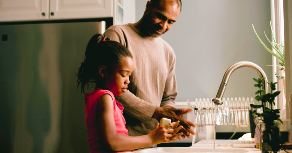 dad washing hands with his daughter