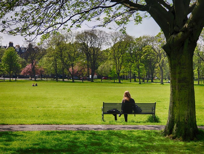 lonely or pensive-looking woman on a bench