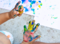 toddler with paint on their hands during a mommy and me playgroup