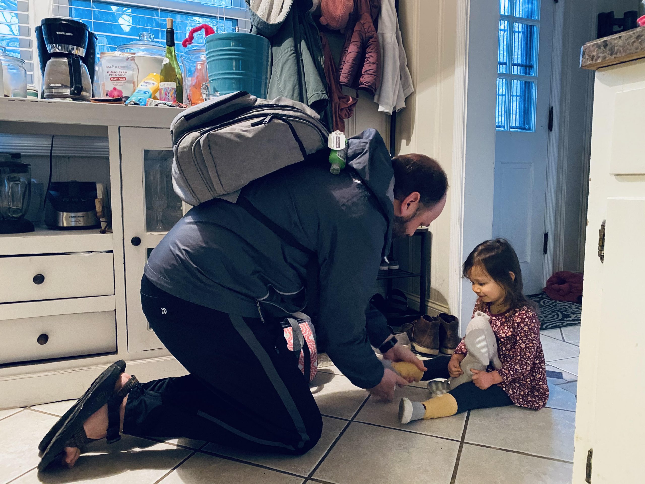 Morning routine dad putting on his daughter's shoes