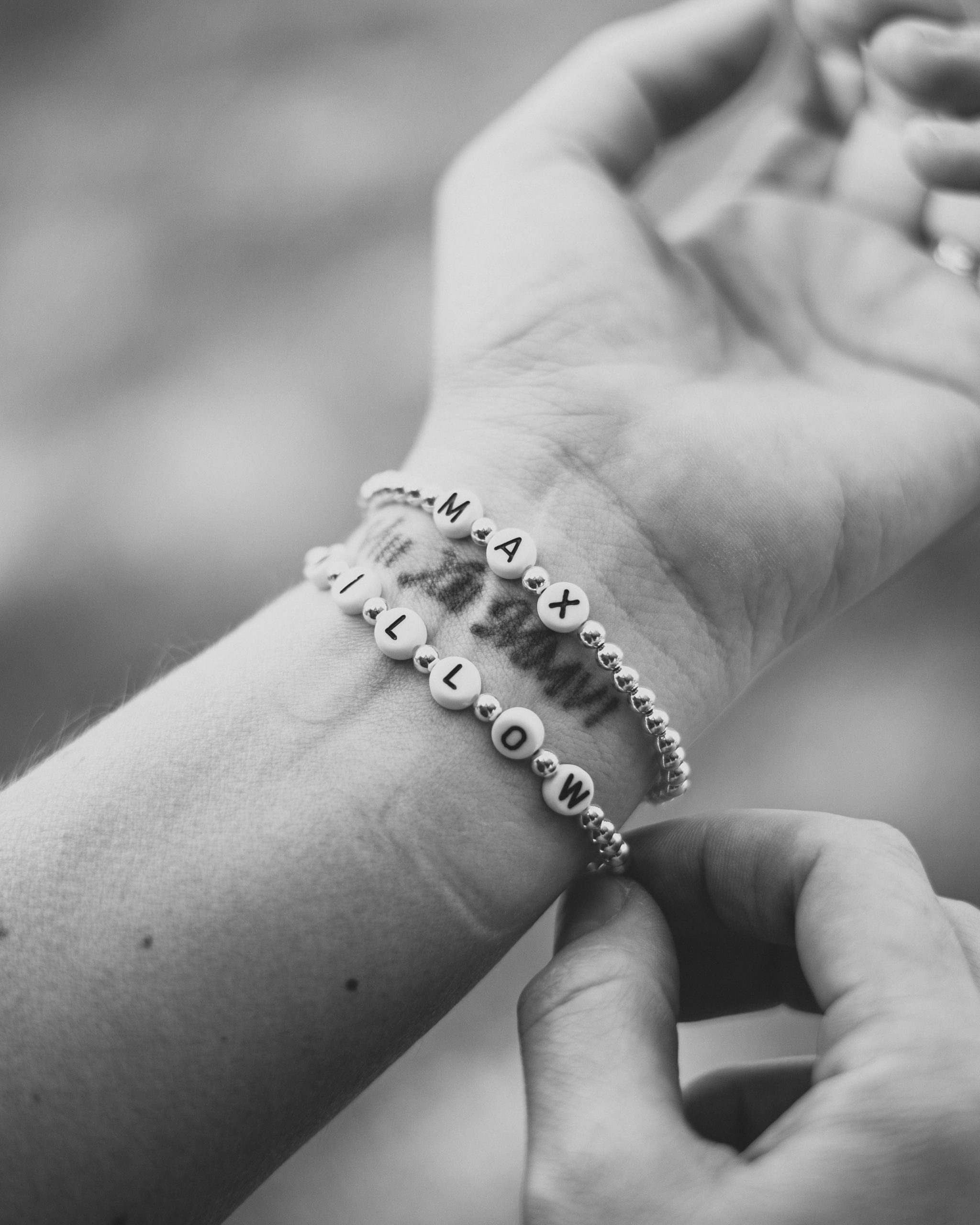 name bracelets on a woman's arm
