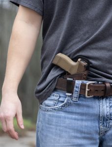 gun tucked into a pair of jeans