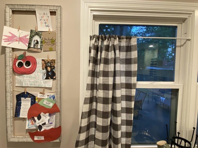 Picture frame with pictures and artwork clipped to yarn