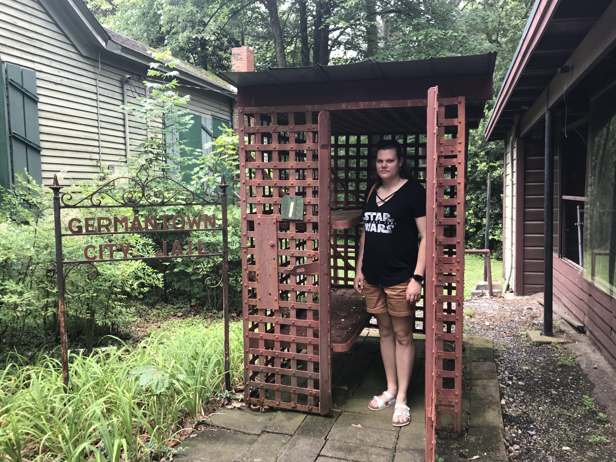 woman in square orange cage titled "Germantown City Jail"