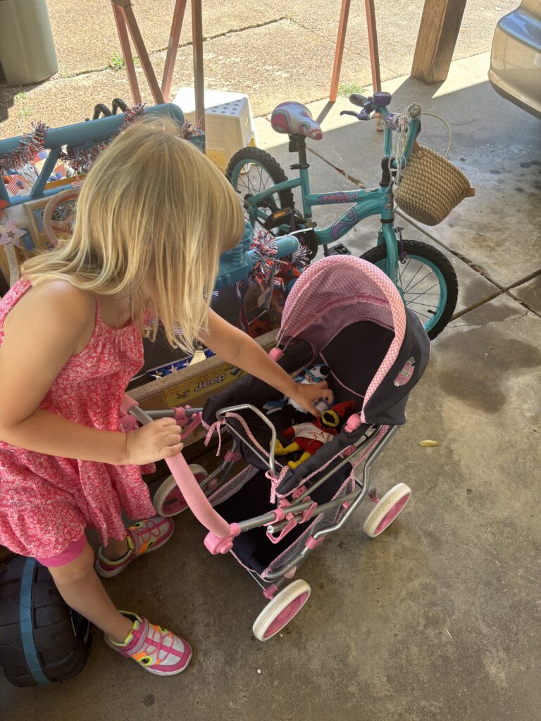 preparing for a sibling by practicing with her babies