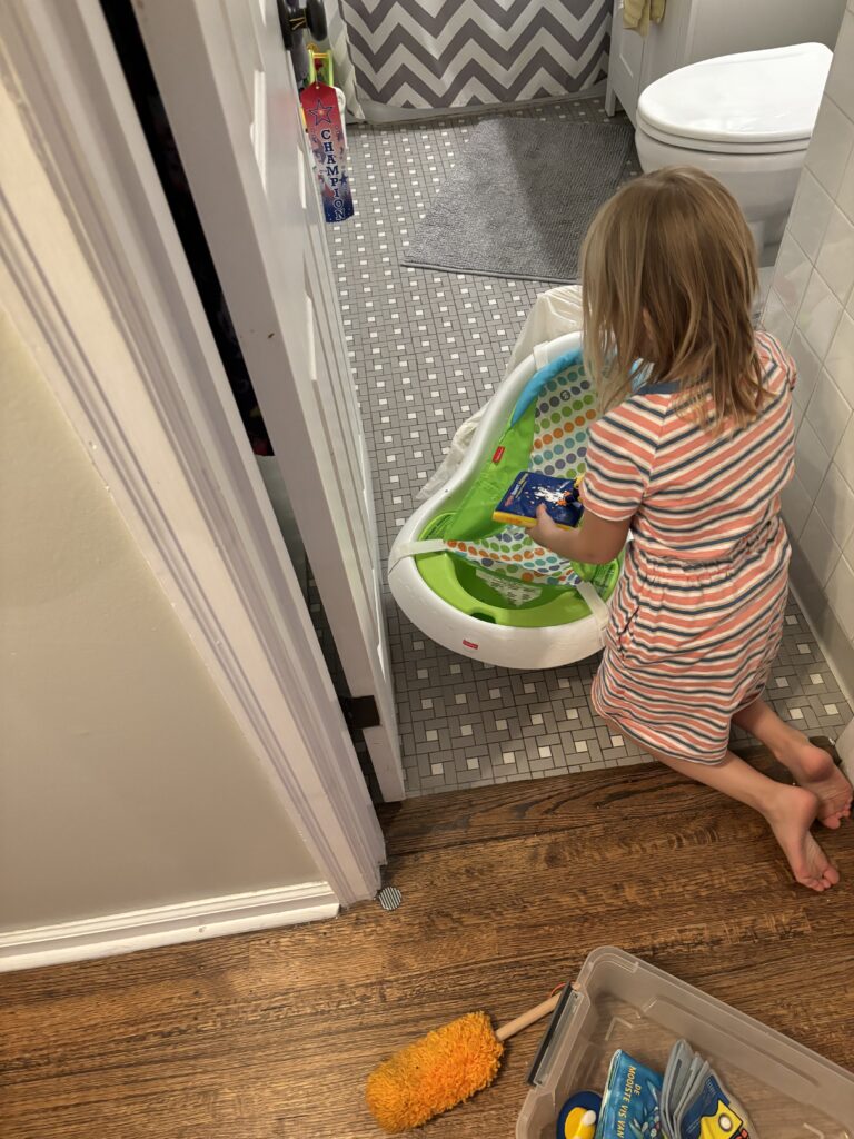 preparing for a sibling by helping clean toys