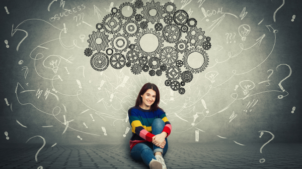 woman sitting under a graphic of brain