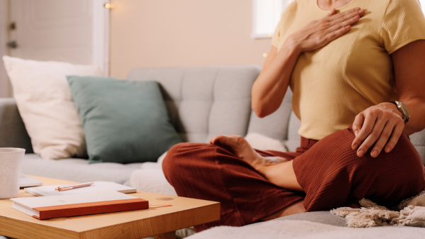 woman performing breathwork on her couch