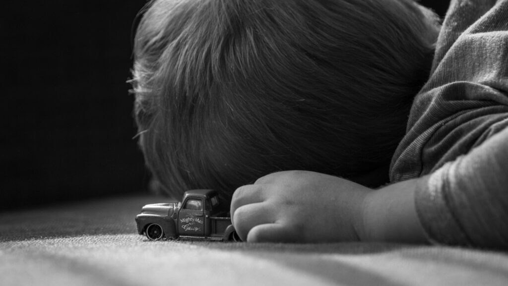 child with autism holding a toy truck